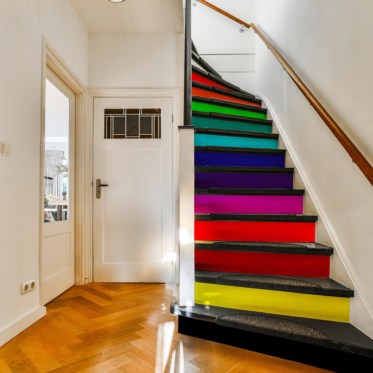Colorful staircase transformed with vibrant rainbow stair riser decals for a stylish home upgrade.