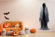 Eerie ghostly wall sticker in a cozy Halloween-themed living room with pumpkins and ghost decorations.