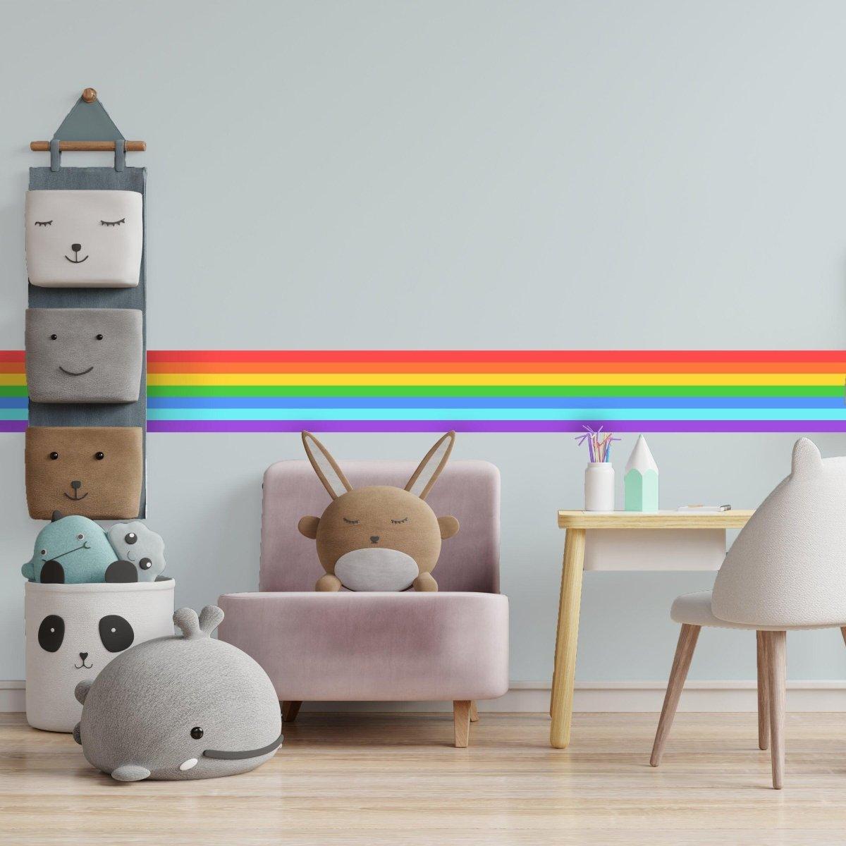 Colorful rainbow stripe vinyl sticker on a wall in a playful, cozy children's room with cute plush toys.