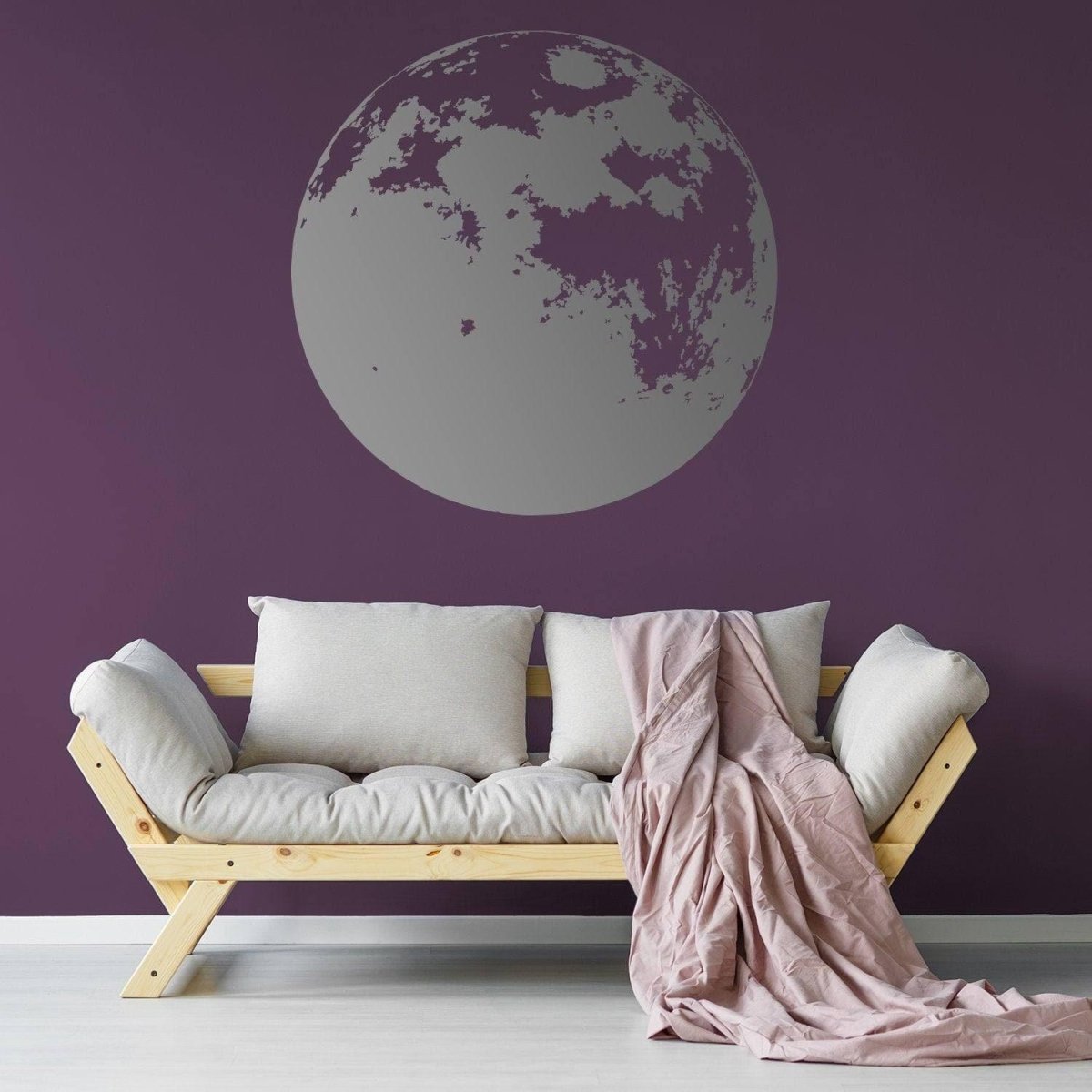 Vinyl wall sticker of a large moon on a purple wall, enhancing a cozy living space with modern decor.