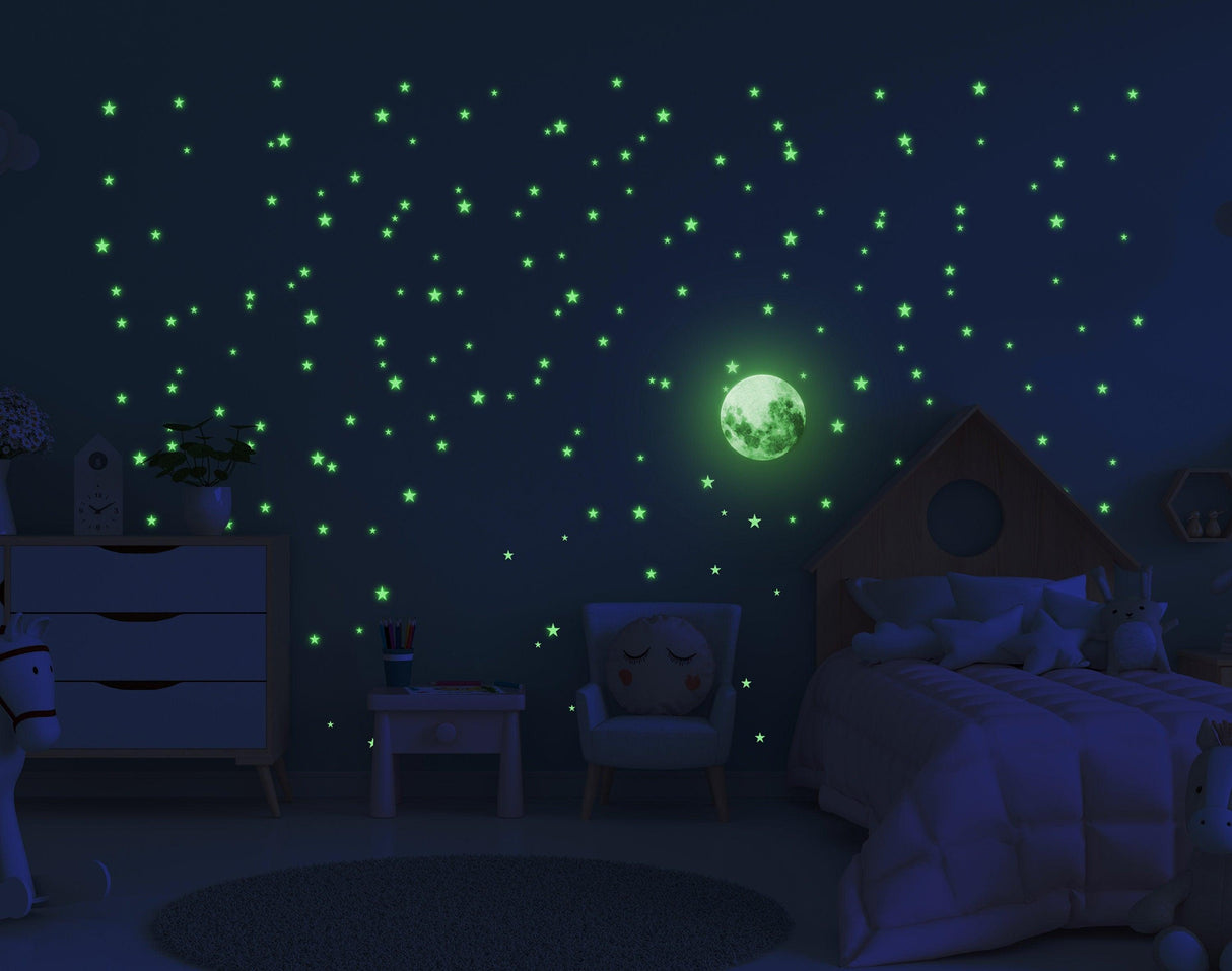 Glowing star stickers and moon decal on a dark wall, creating a magical night sky in a child's bedroom.