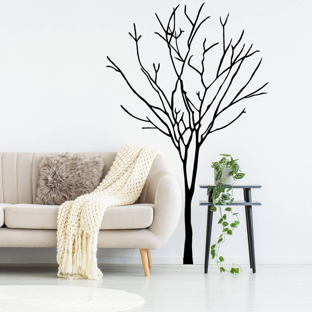 Tree wall decal in a modern living room with cozy sofa and plants, showcasing nature-inspired home decor.