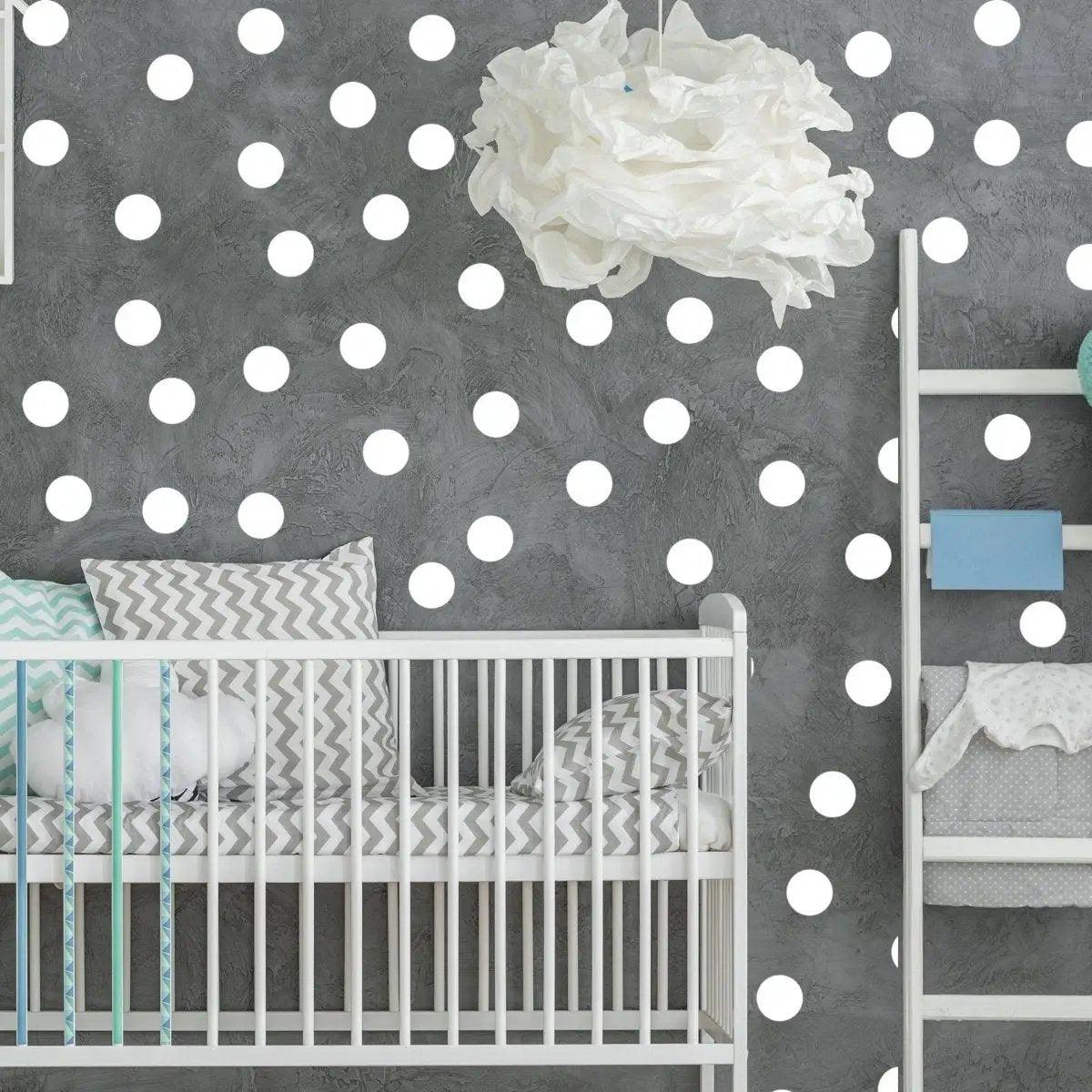Colorful 2-inch round dot wall stickers applied to a grey nursery wall with a crib and decorative accessories.