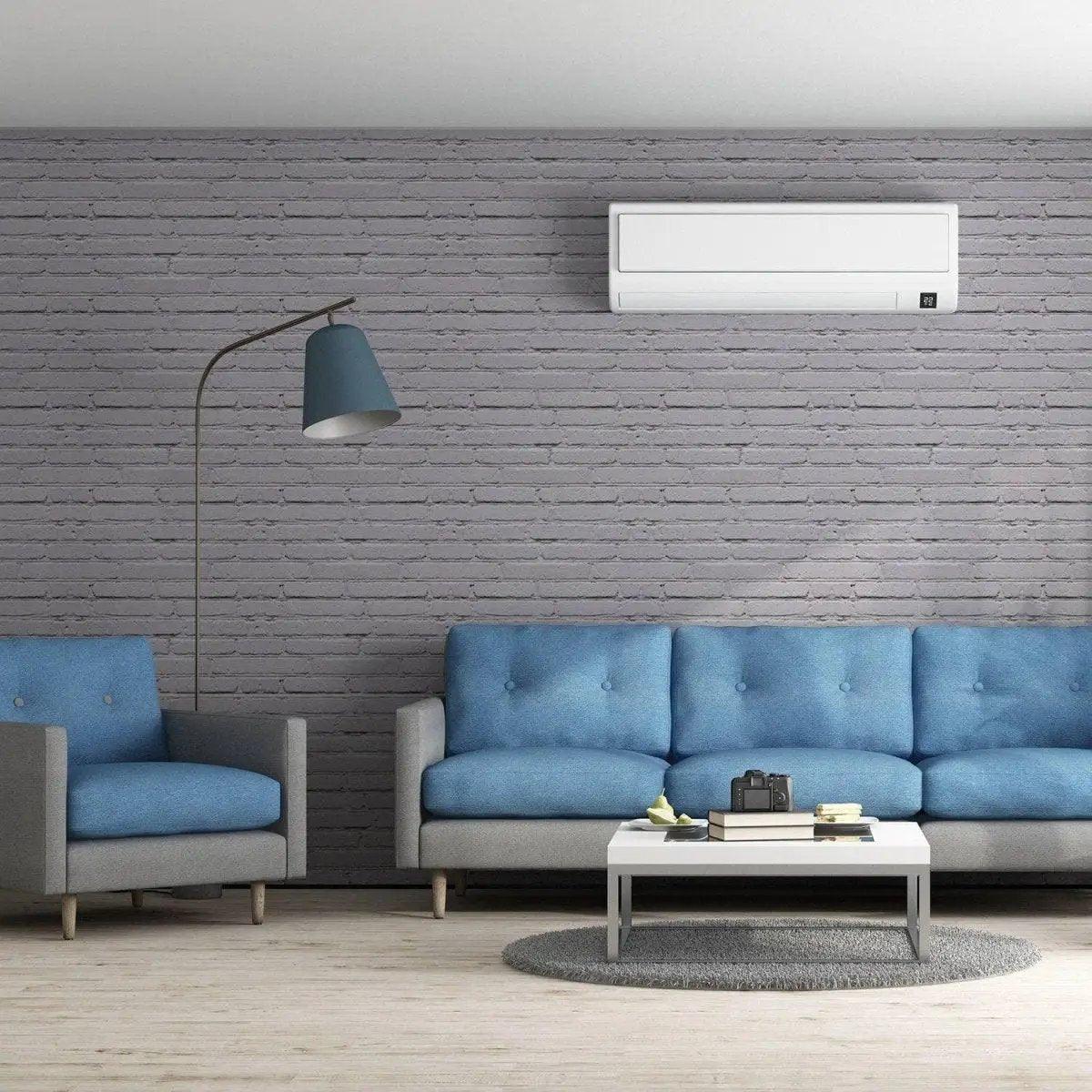 Living room featuring blue sofas against a stylish grey brick wall with a modern lamp and air conditioning unit.