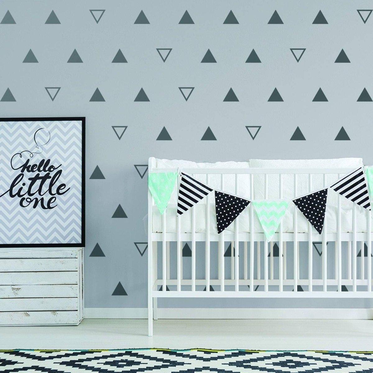 Geometric triangle wall decals in a nursery, featuring a crib and decorative banners.