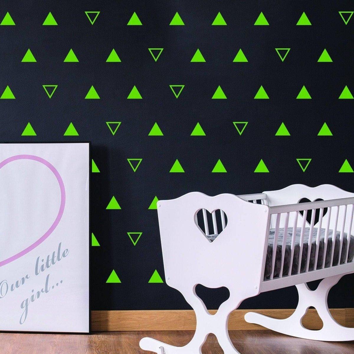 Geometric triangle wall decal set for nursery, featuring vibrant green stickers on black wall with cute crib.