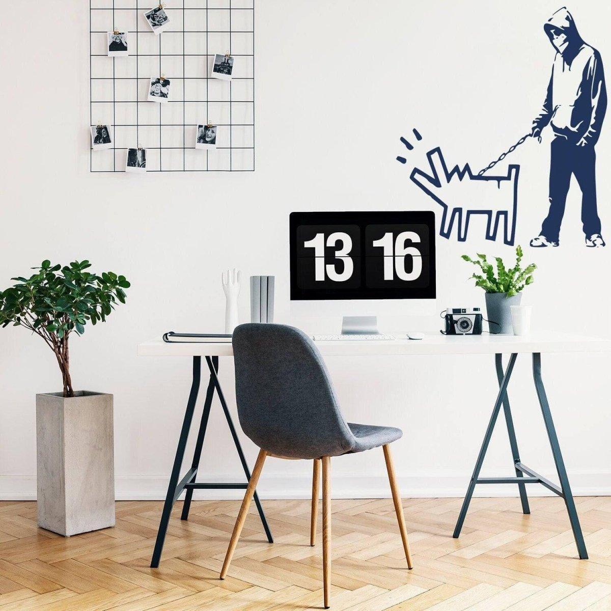 Banksy-style wall art decal of a person walking a dog in a modern home office decor setting.