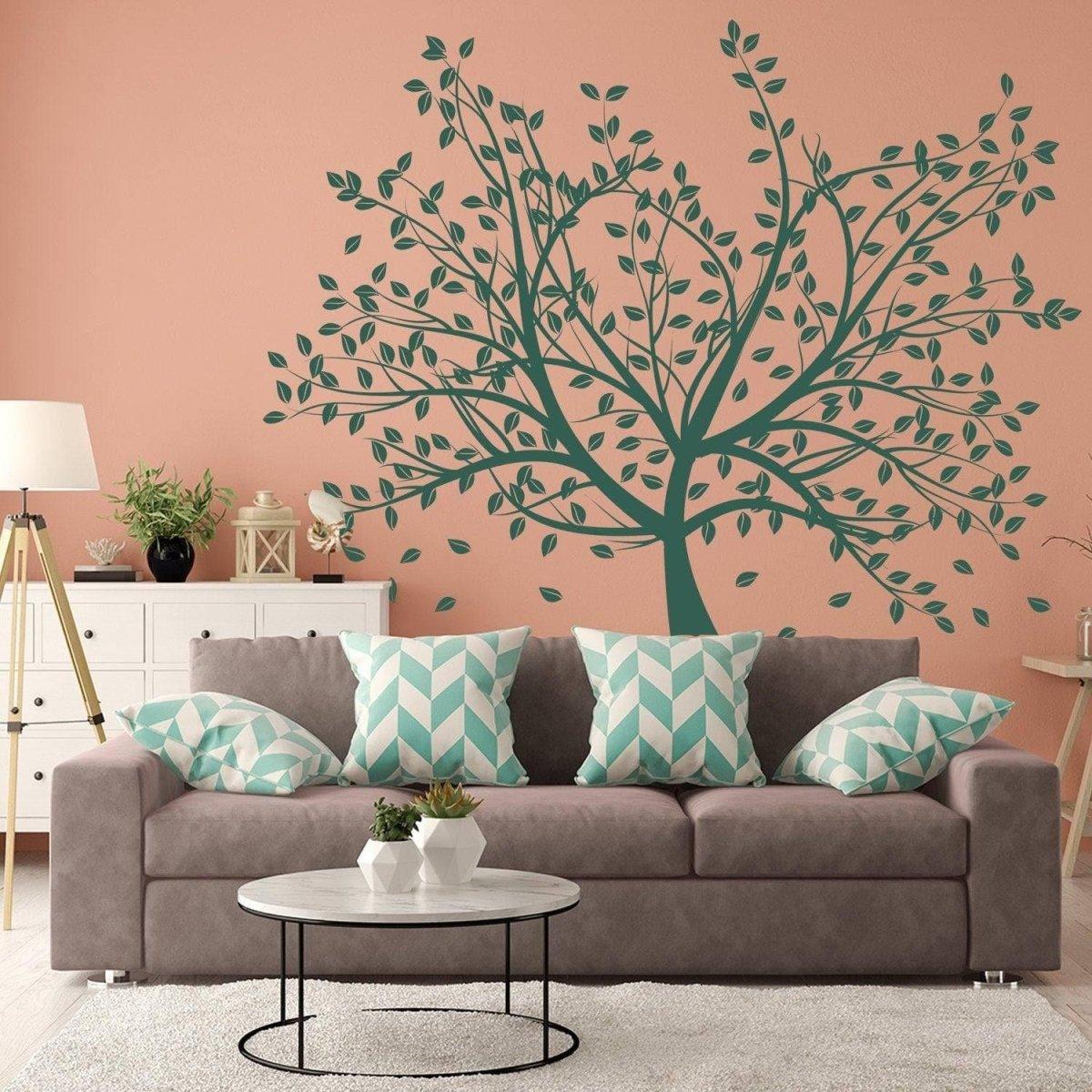Birch Grove vinyl wall decal displayed above a cozy grey sofa with turquoise leaf designs on a peach wall.
