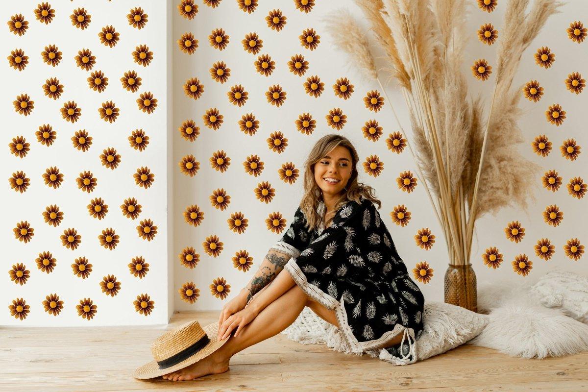 Boho Daisy wall stickers in a cozy room with a smiling woman sitting on the floor, wearing a black dress and straw hat.