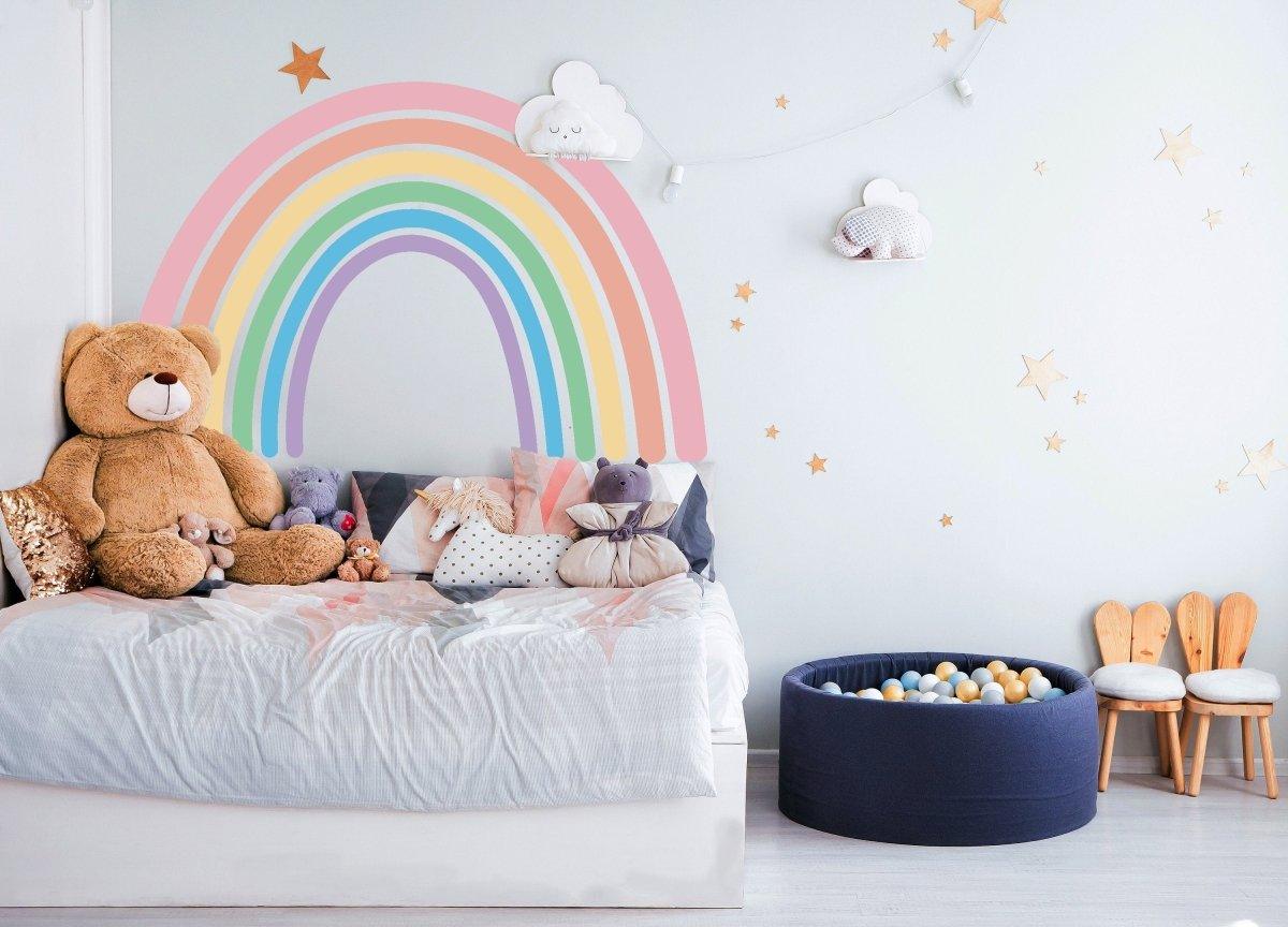 Boho aesthetic rainbow wall sticker in a cozy nursery with a teddy bear and plush toys.