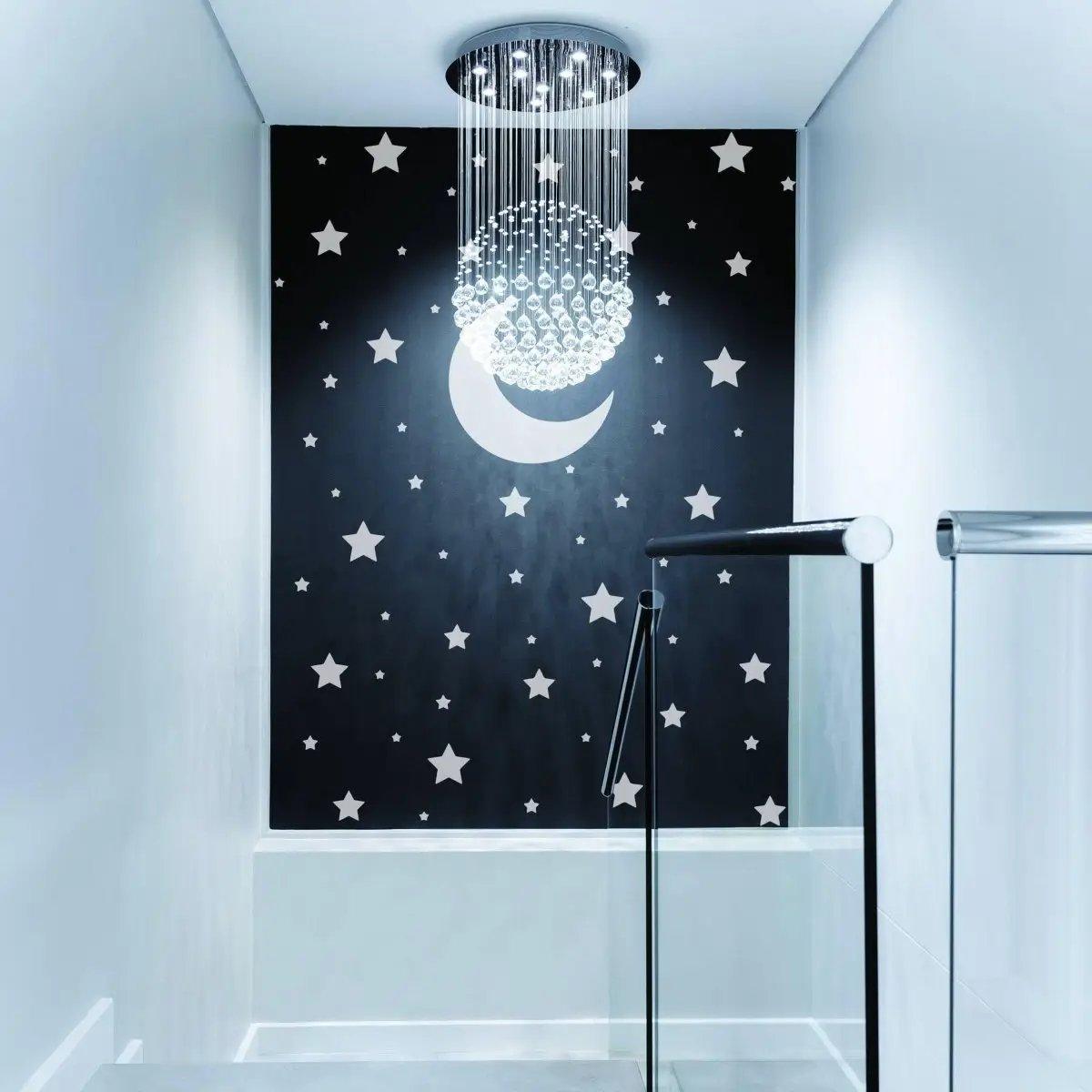 Elegant wall featuring celestial stars and moon decals with a stylish chandelier above.