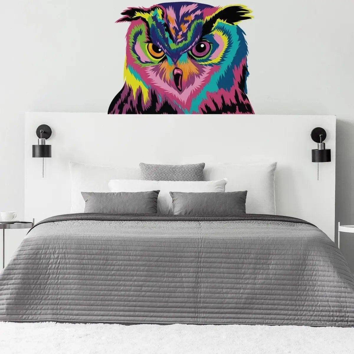 Colorful owl wall sticker above a stylish gray bed, adding charm and personality to the bedroom decor.
