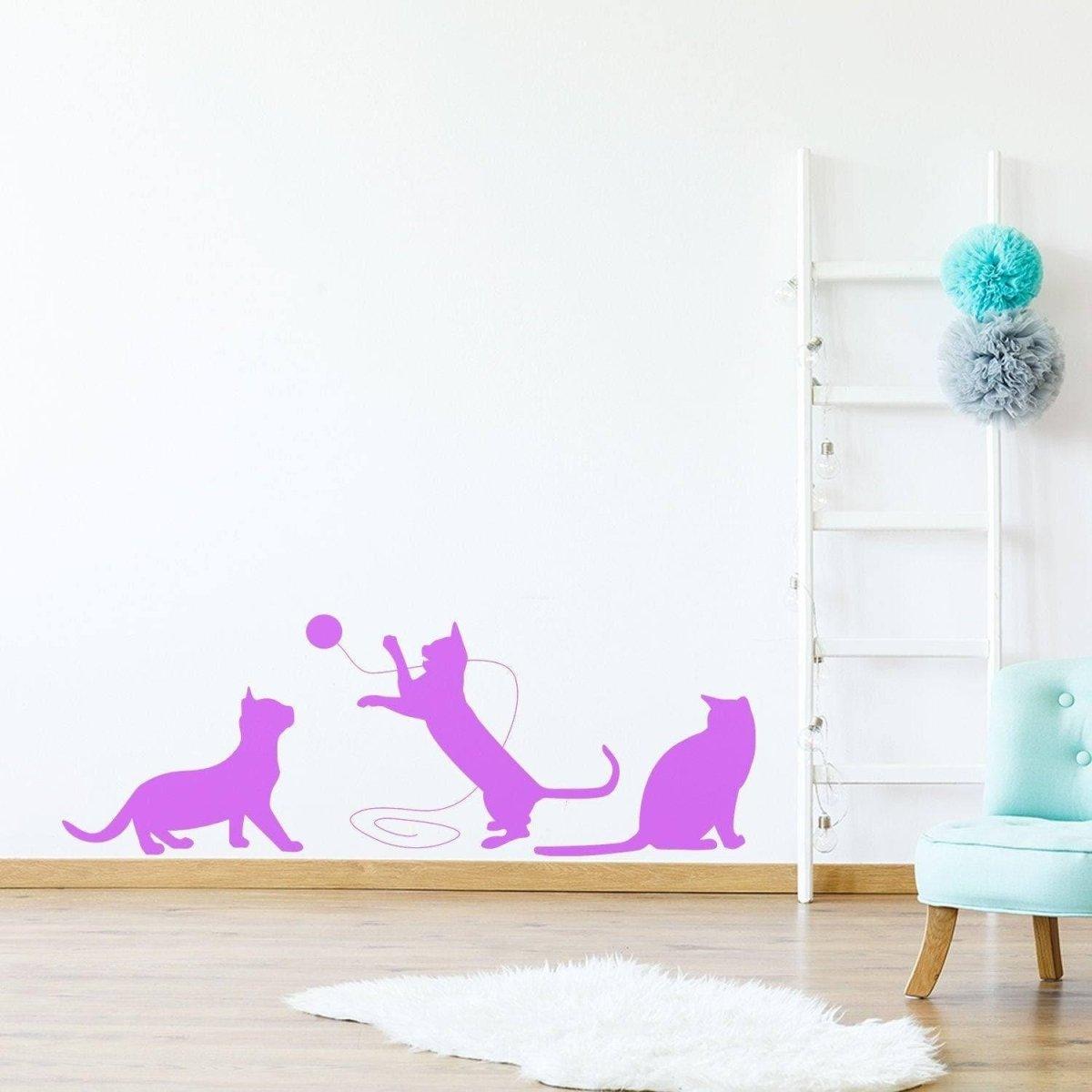 Adorable pink vinyl cat silhouette decal depicting playful cats on a wall, perfect for pet-themed home decor.