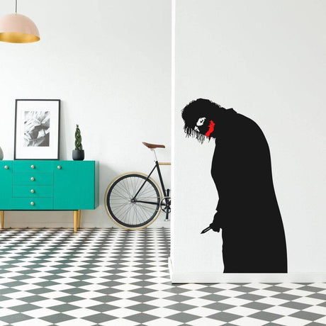 Creepy clown vinyl decal with menacing smile on a wall, adding a spooky touch to modern decor.