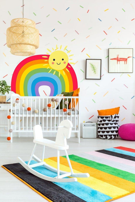 Colorful nursery with vibrant rainbow wall decal, sunny design, and playful decor for a joyful atmosphere.