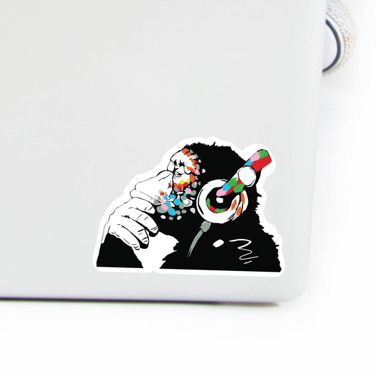 Contemplative monkey vinyl laptop decal with headphones, colorful design for personalizing computer devices.