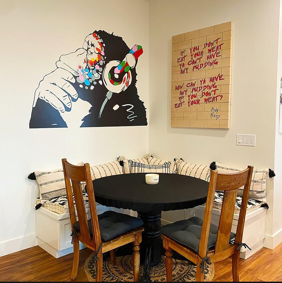 Cool monkey wall decal in a dining area with a playful quote on the wall, featuring a cozy seating arrangement.