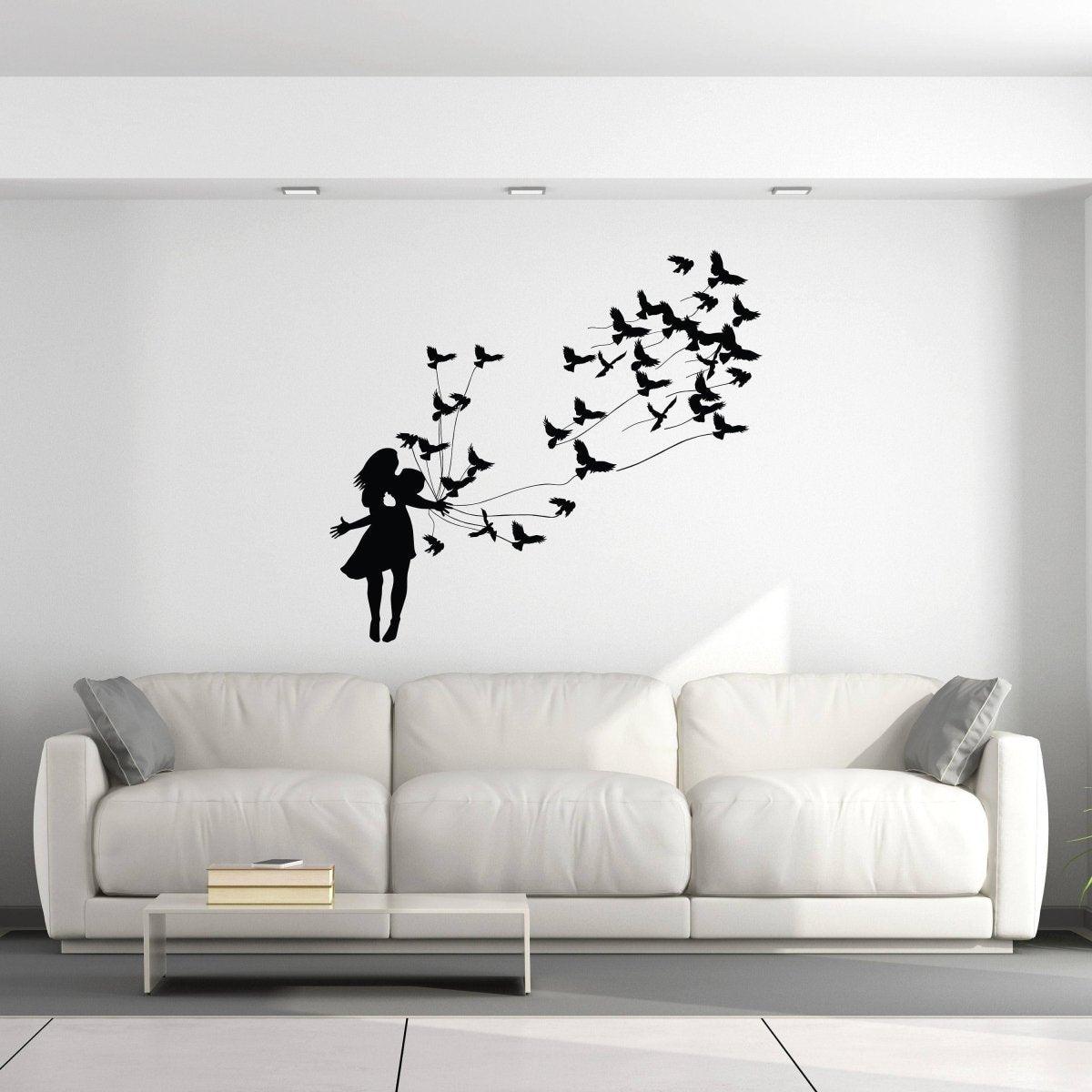 Girl silhouette wall sticker releasing birds above a stylish white sofa in a modern living room.