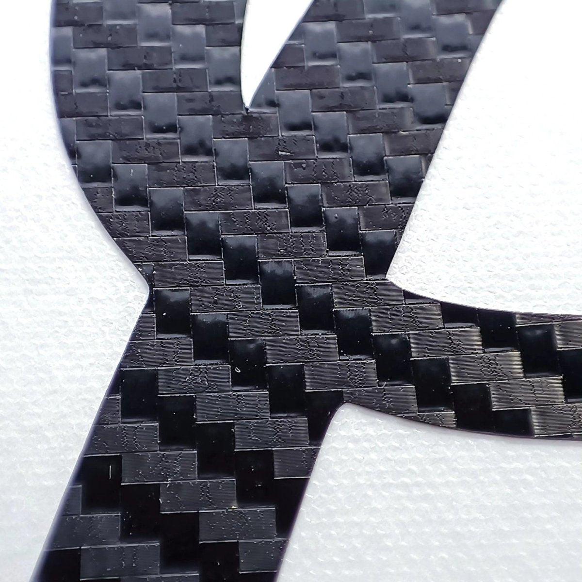 Close-up of personalized carbon fiber letter sticker showcasing a sleek, durable vinyl texture.