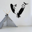 Stylish bird feather wall sticker design in black on a white wall above a geometric play tent.