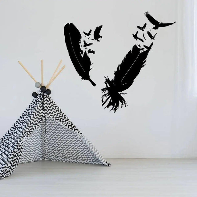 Stylish bird feather wall sticker design in black on a white wall above a geometric play tent.