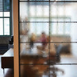 Frosted window film decal offering privacy while allowing natural light to illuminate a modern workspace.