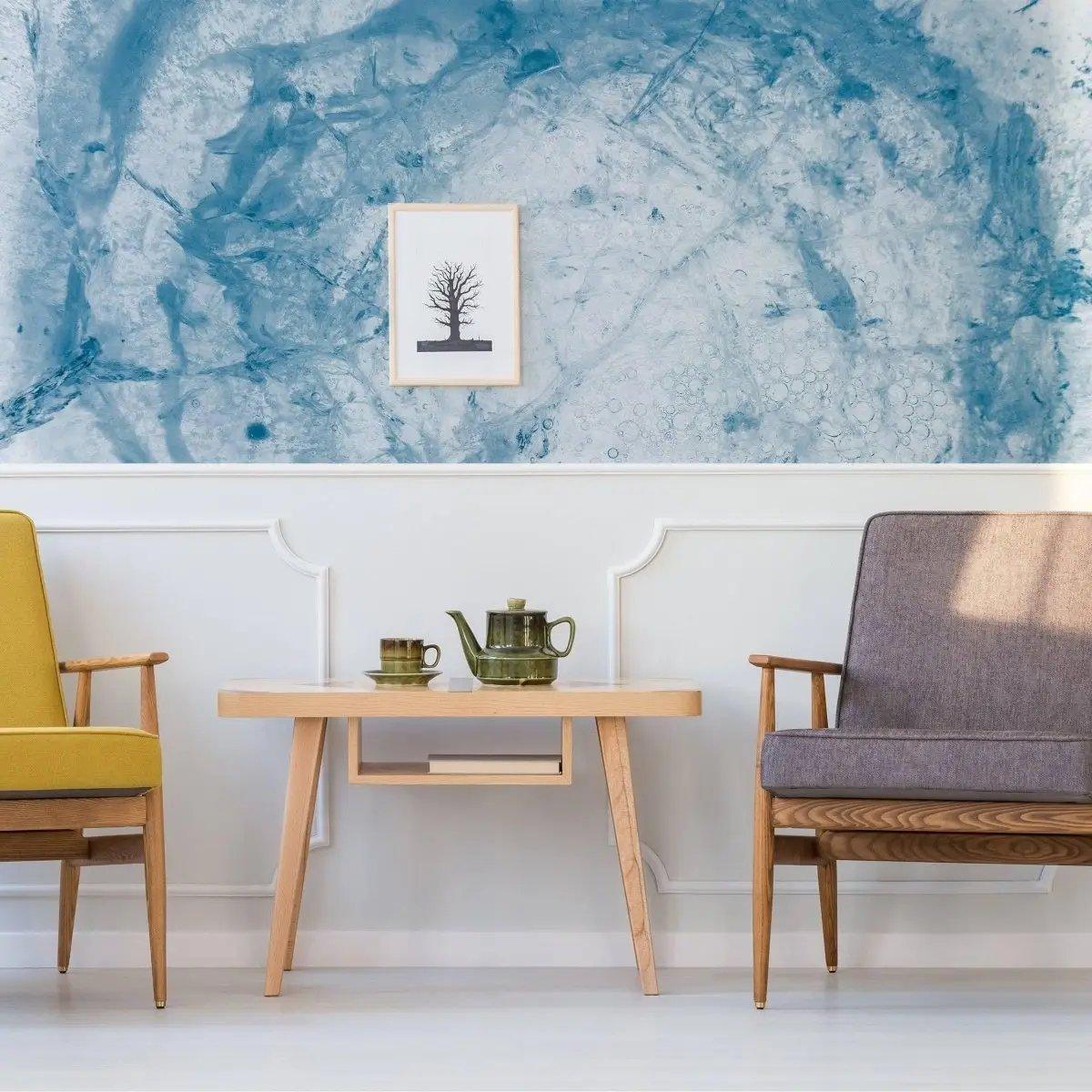 Sophisticated blue marble effect wallpaper in a modern living room with stylish chairs and a decorative table.