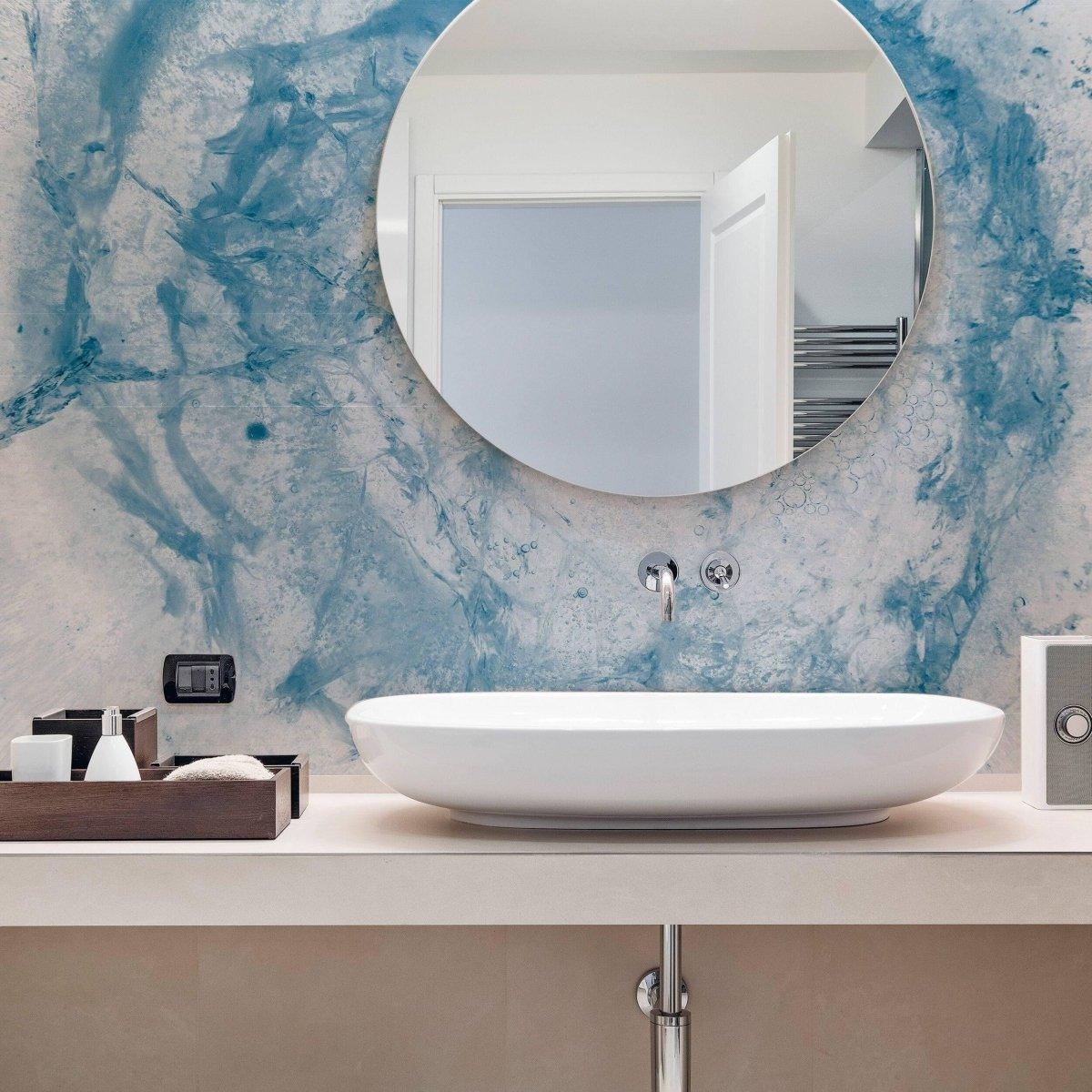 Elegant bathroom featuring blue marble effect wallpaper and a round mirror above a modern sink.