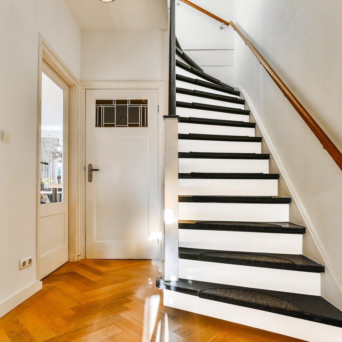 Elegant white staircase with stylish black risers showcasing the beauty of a staircase makeover.