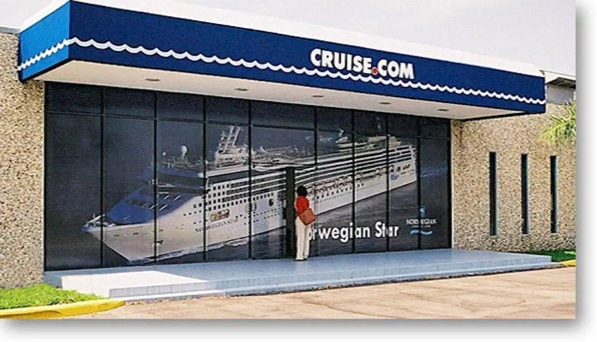Window display featuring a large graphic of the Norwegian Star cruise ship at Cruise.com office.