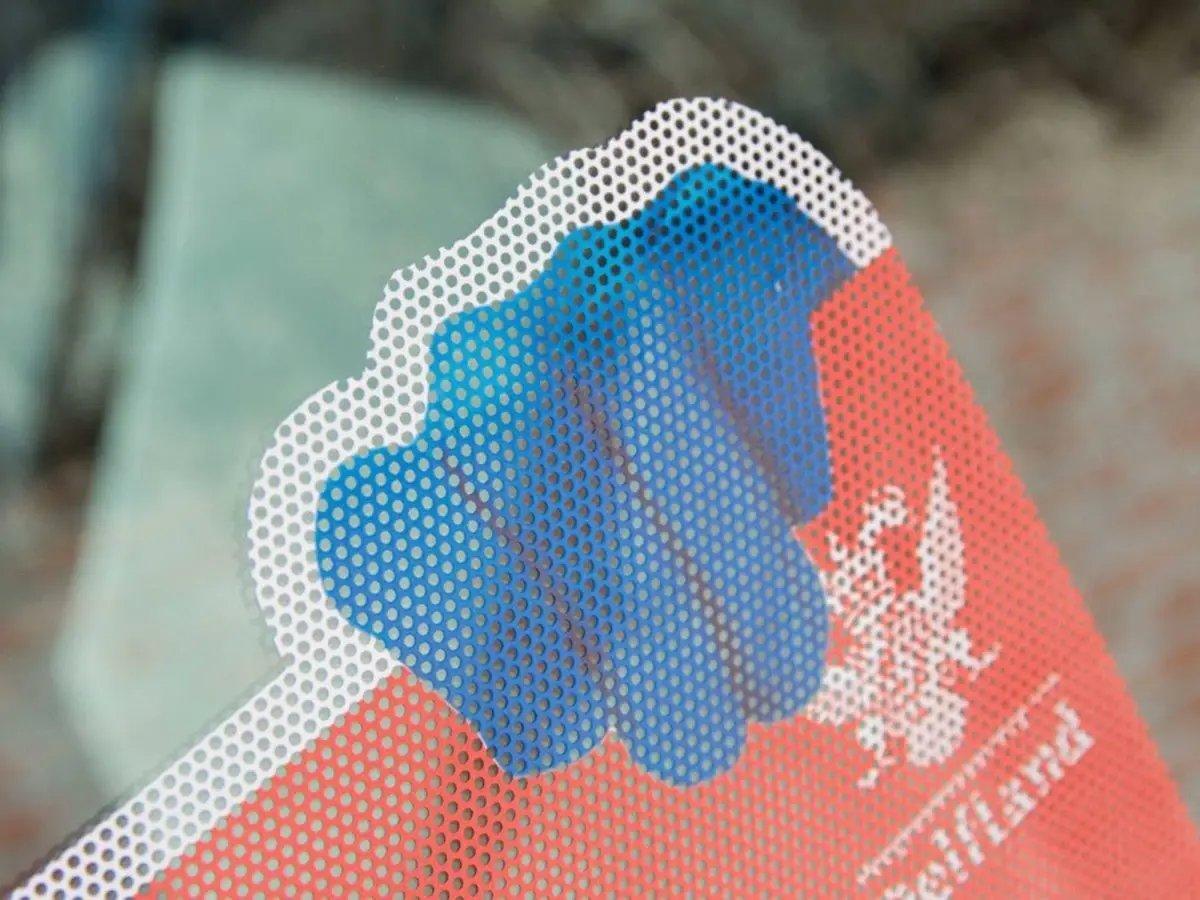 Close-up of advanced clarity one-way vision privacy film showing perforated design and vibrant colors.