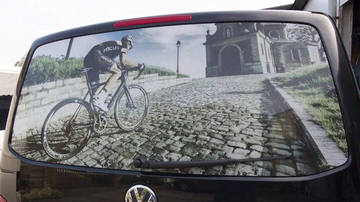 Custom one-way window film showing a cyclist on a cobblestone road for privacy and style.