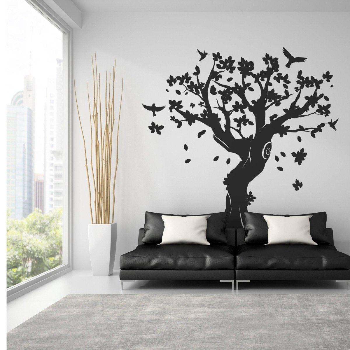 Contemporary tree wall art in living room, black vinyl decal on white wall, stylish home decor.