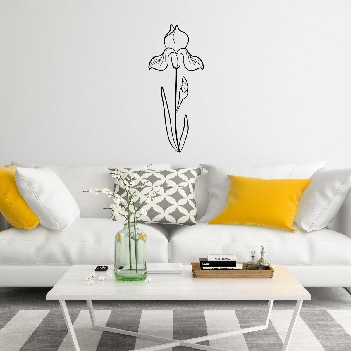 Stylish birth flower decal of an iris flower above a modern couch with yellow pillows and a coffee table.