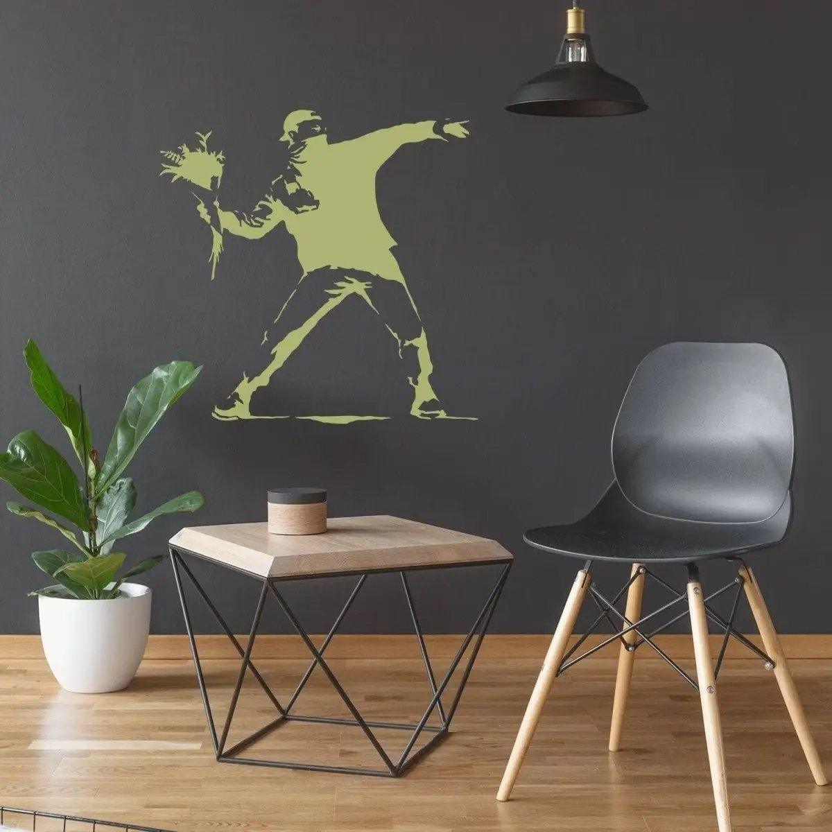 Banksy-inspired flower wall decal in modern living room with plant and geometric table.