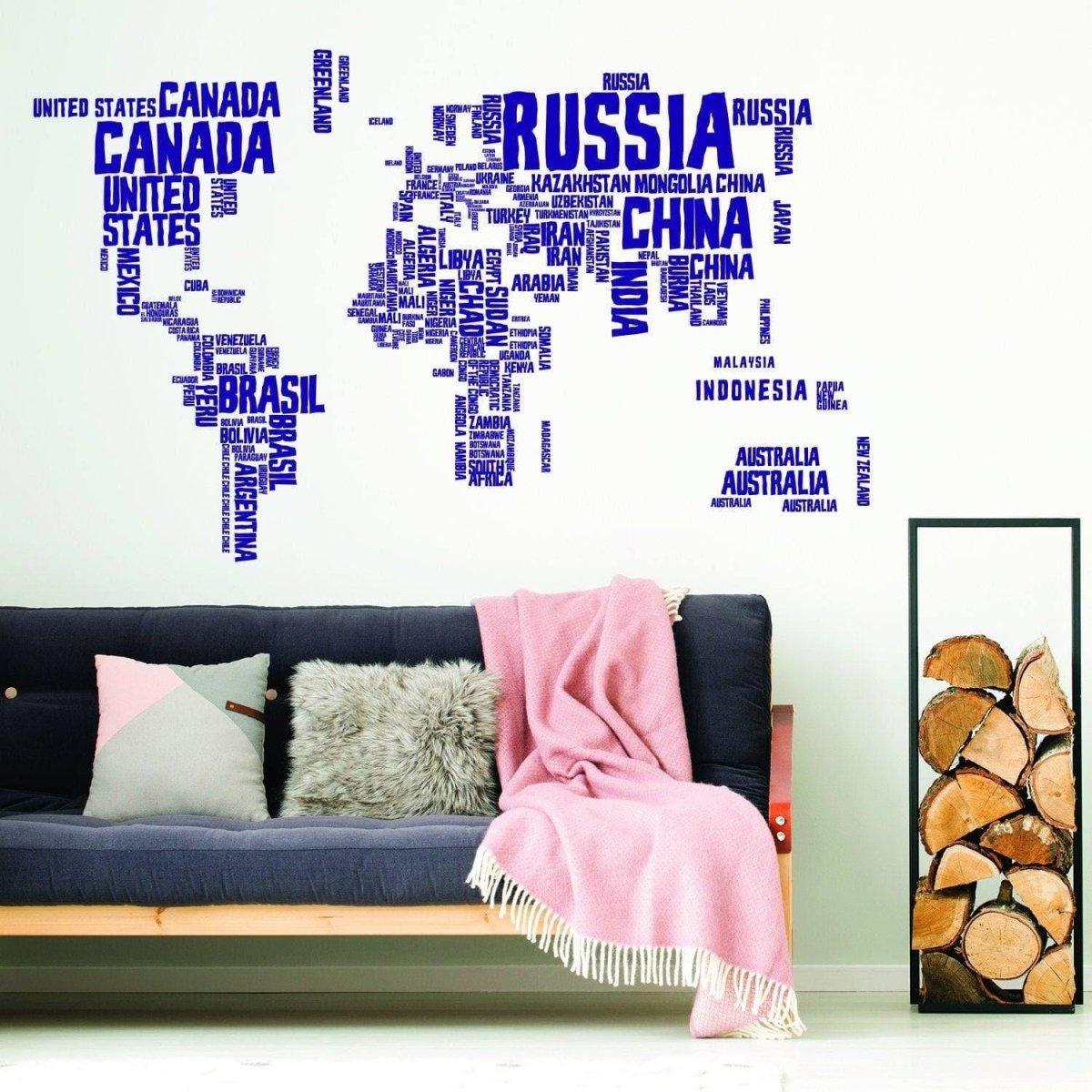 World Expedition Wall Sticker featuring country names on a wall above a cozy sofa with pink throw blanket.
