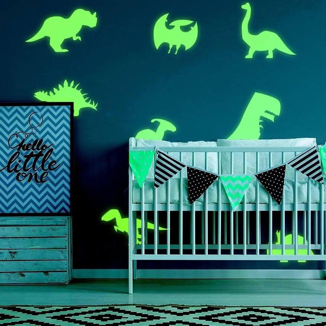 Glow-in-the-dark dinosaur wall decals in a stylish nursery with crib and decorative banners.
