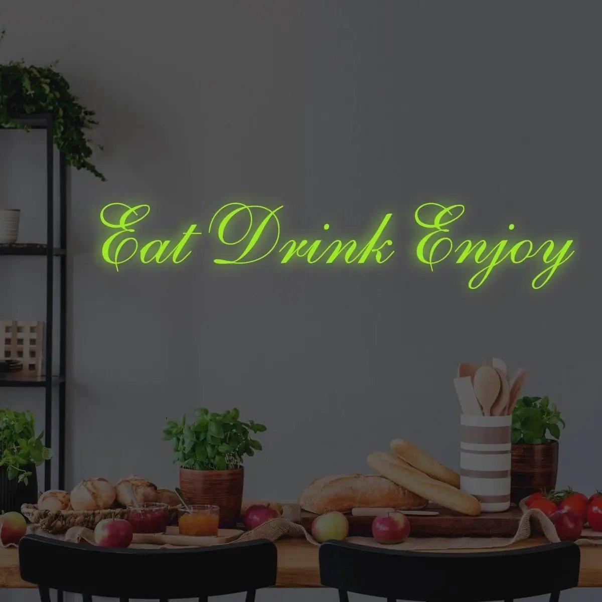 Illuminated vinyl decal saying 'Eat Drink Enjoy' glowing on kitchen wall with fruits and herbs.