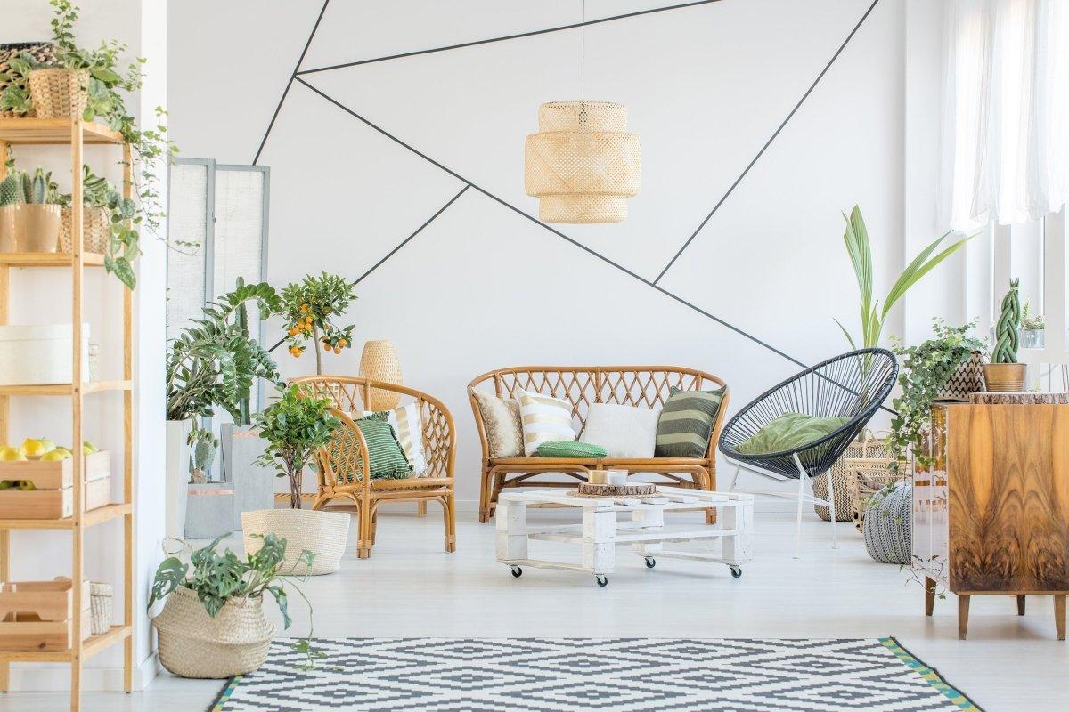 Stylish living room with geometric wall art, rattan furniture, and indoor plants for a modern decor.