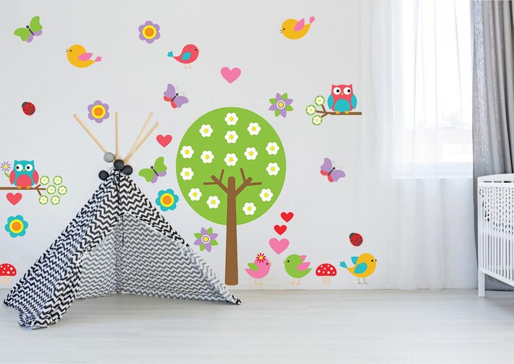 Nursery tree wall decal with colorful birds, owls, flowers, and a teepee in a child's room.