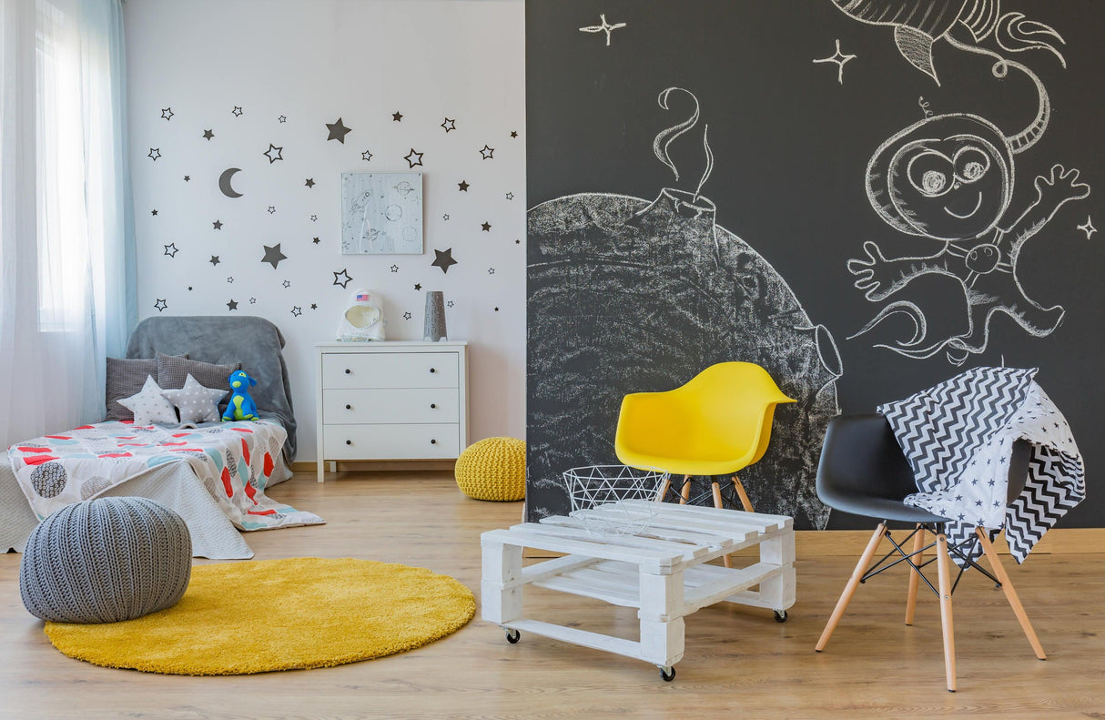 Modern playroom with chalkboard wall art, yellow chair, and cozy decor elements for a creative environment.