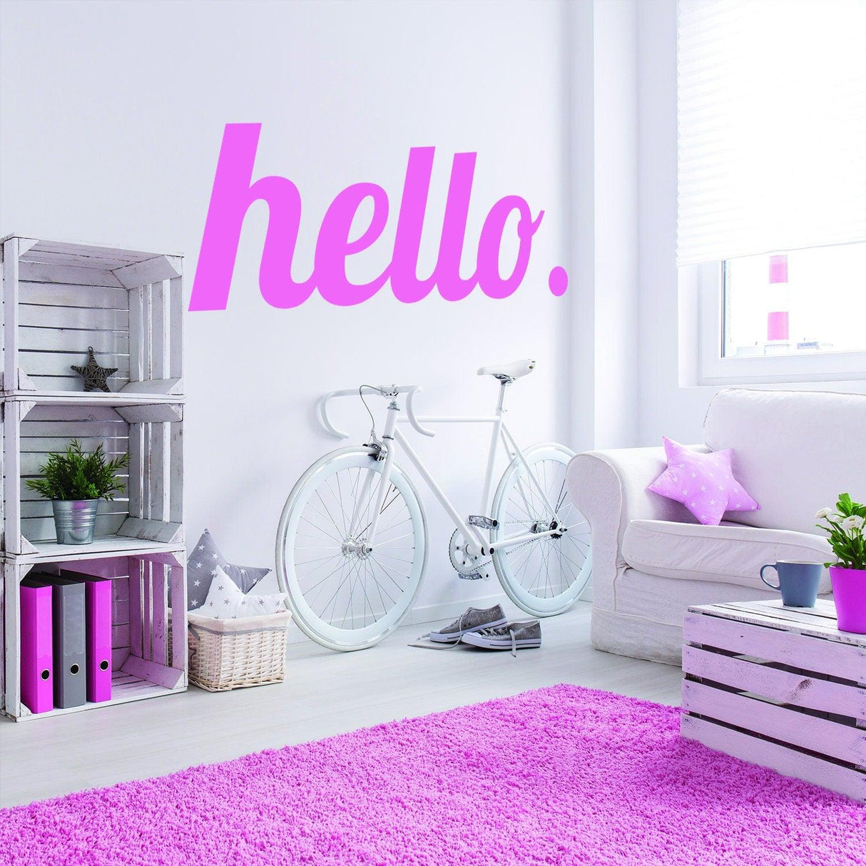Hello vinyl sticker on wall with pink color, surrounded by modern decor and a bicycle in a stylish interior.