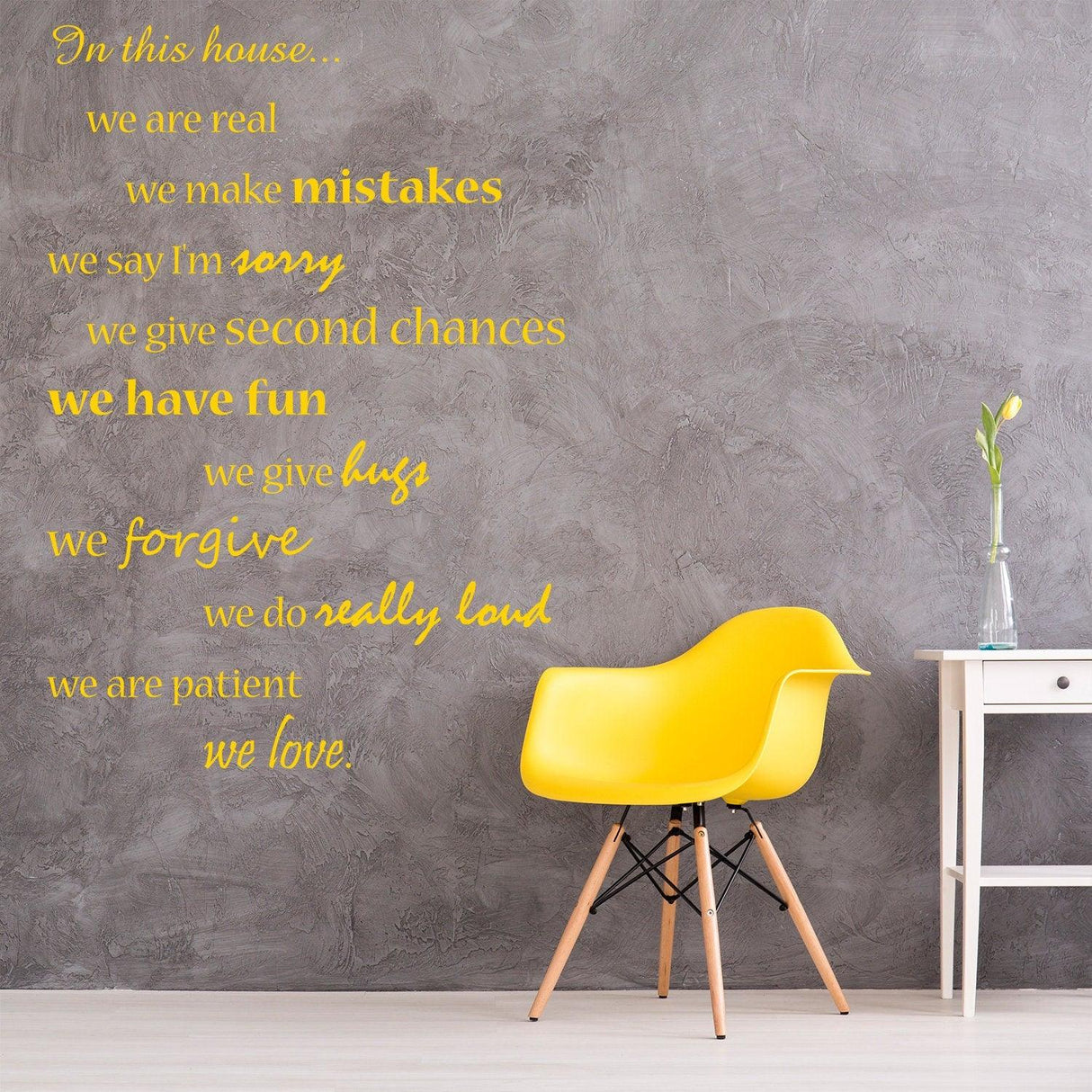 House wall quote sticker decal with family rules on gray wall beside yellow chair.