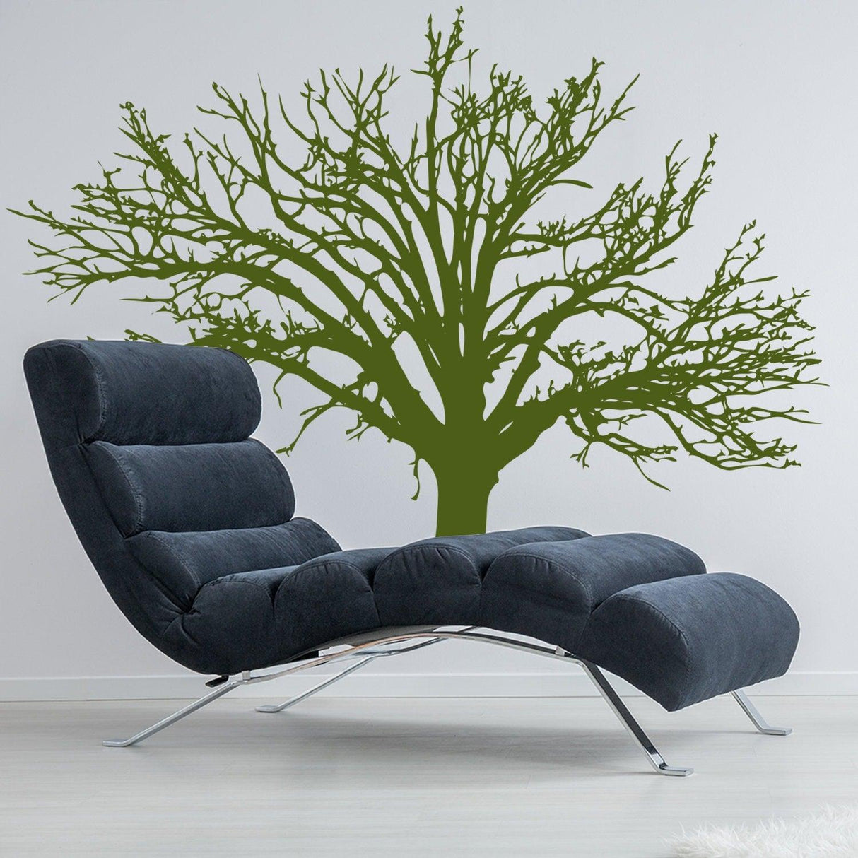 Stylish wall decal of an intricate green tree behind a modern lounge chair, perfect for home decor.