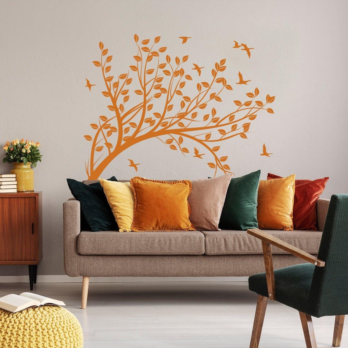 Decorative orange tree branch wall decal with birds in a cozy living room setting.