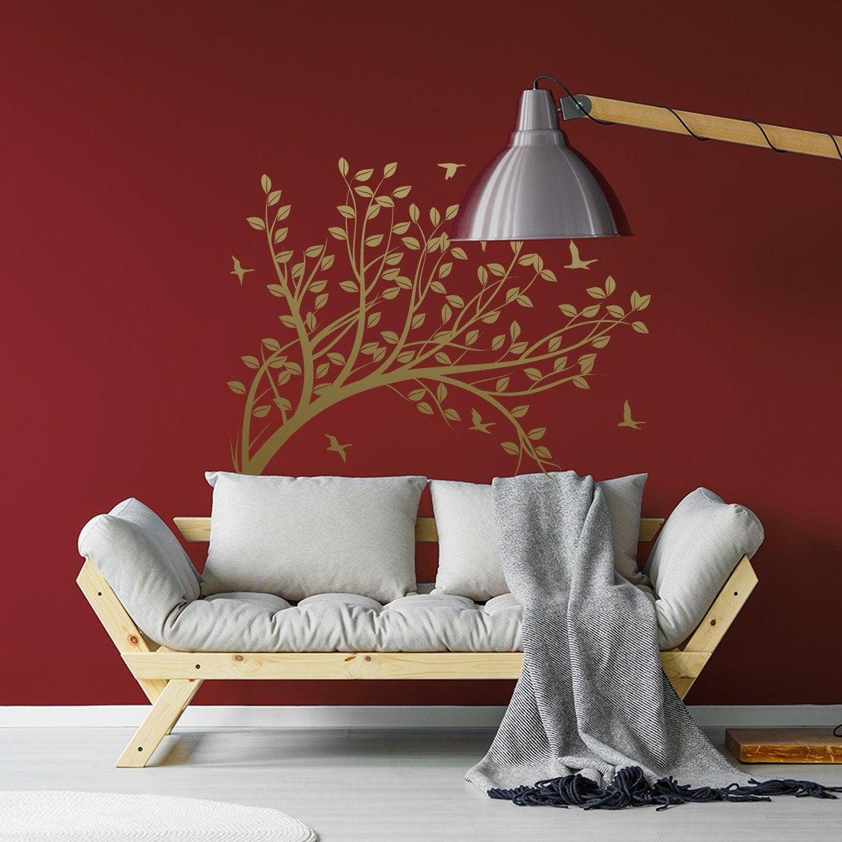 Vinyl wall decal of tree branch with leaves and birds, enhancing a cozy, stylish living room.