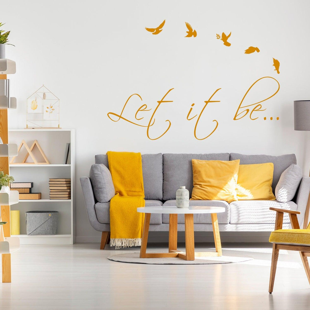 Living room featuring 'Let it be...' wall sticker with birds, stylish furniture, and warm decor accents.