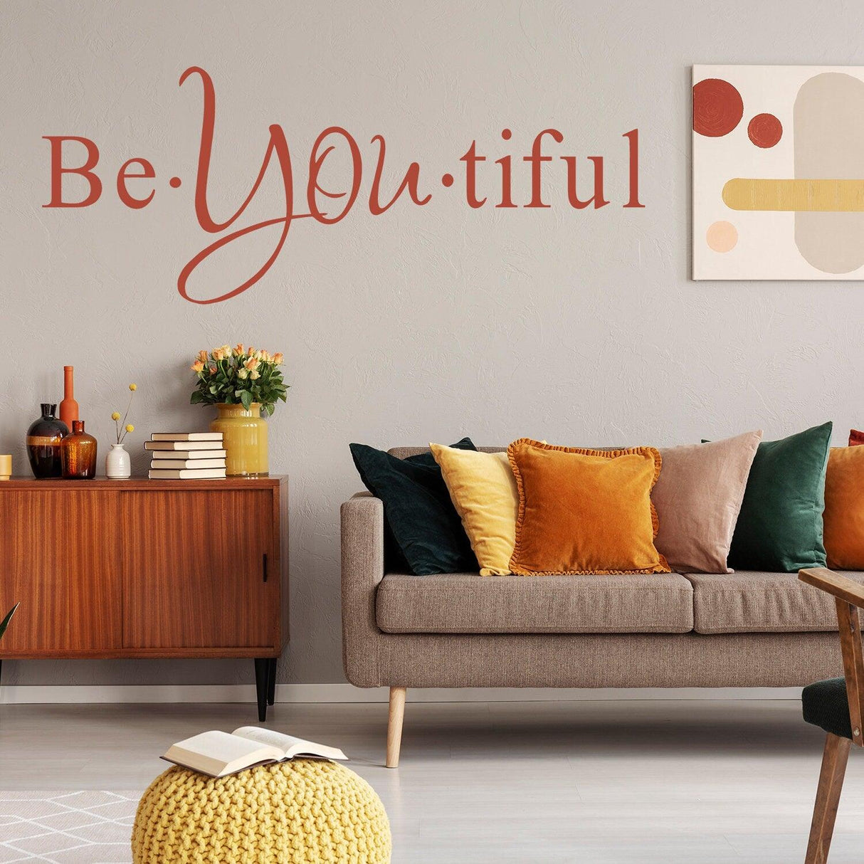 Inspirational wall sticker 'Be YOU tiful' in a modern living room with cozy decor and colorful cushions.