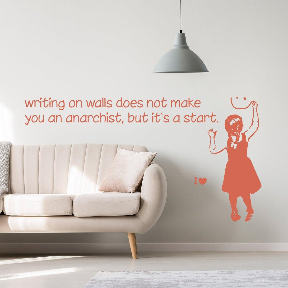 Banksy-inspired wall sticker featuring a girl with a smiley face and a quote about anarchy in a modern living room.