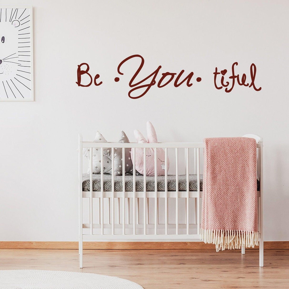 Beautiful quote wall sticker 'Be You Tiful' above a crib, enhancing nursery decor with a charming and inspiring touch.